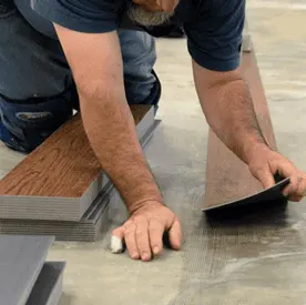 A Stafford's Discount Carpets team member laying down a piece of flooring material